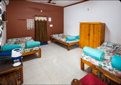 Official gallery image of a resort room with four beds and a wooden desk.