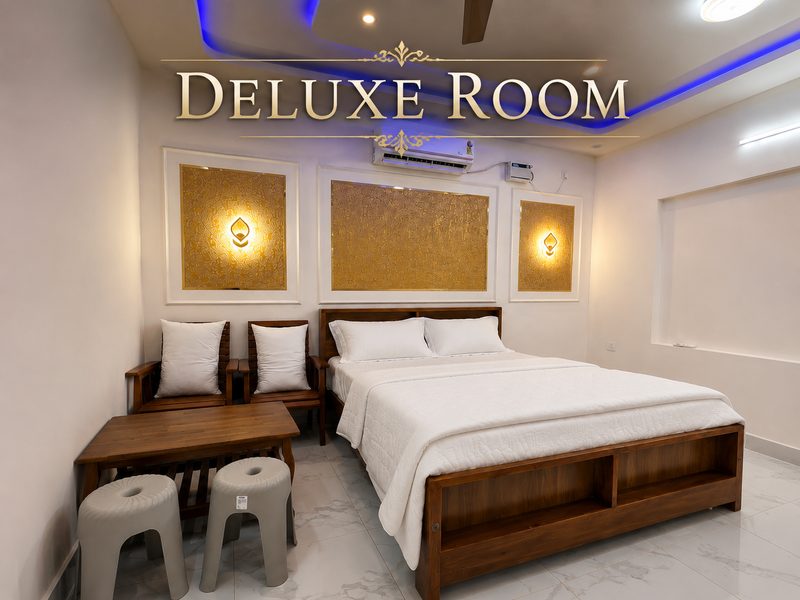 Deluxe Suite 1 — golden-lit bedroom with AC
