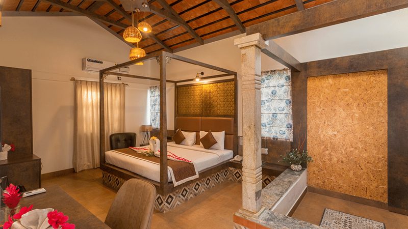 Spacious room with canopy bed and warm lighting at Nirantara Resort.