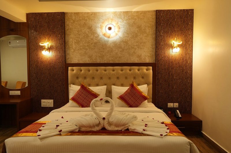 Crown Suite with a king-size bed beneath a lit feature wall
