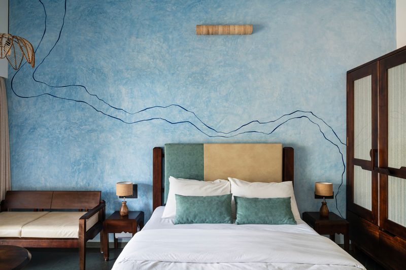 Souparnika, in river blue, with its queen bed and hand-drawn river contours