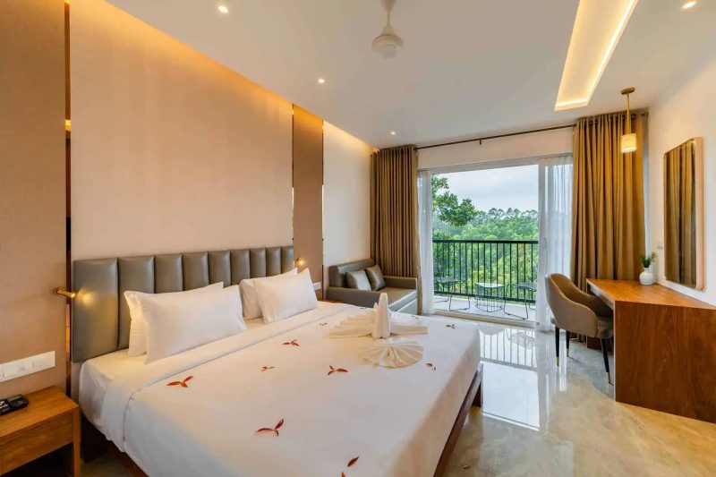 Vega Bliss Cottage king bed with gold curtains and tree-view balcony