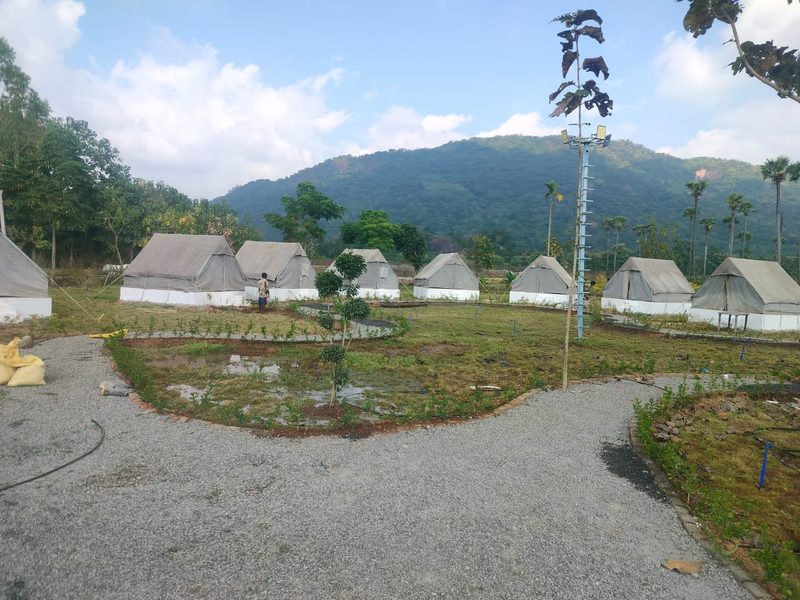 The cottage and tent village ringing a circular lawn beneath the mountain